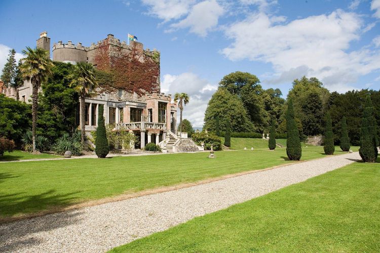 Huntington Castle and its formal lawn beneath a blue sky in County Carlow